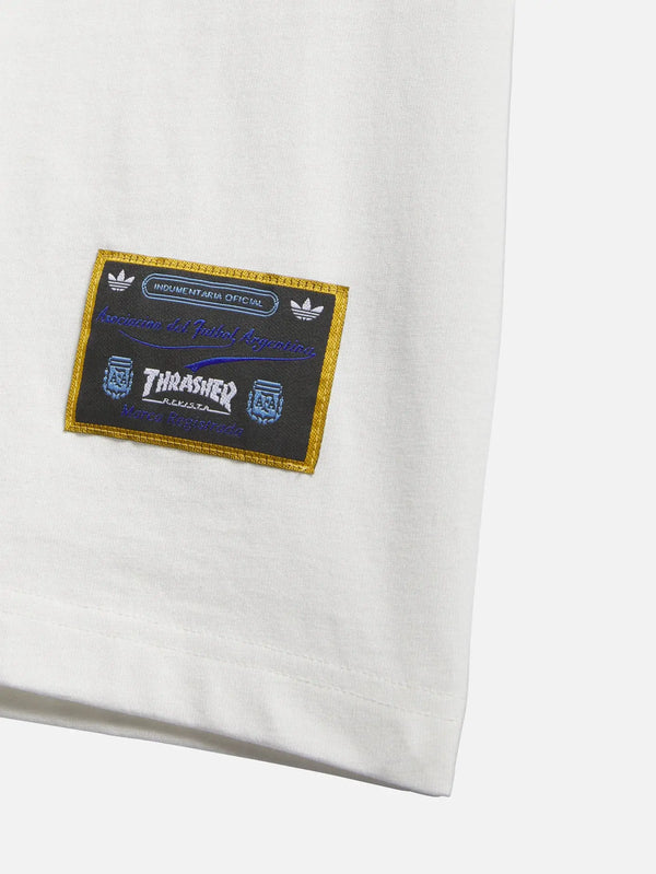 ADIDAS ORIGINALS Thrasher x AFA Argentina Tee 1 - Core White – ön görünüm, altın kenarlı patch detayı