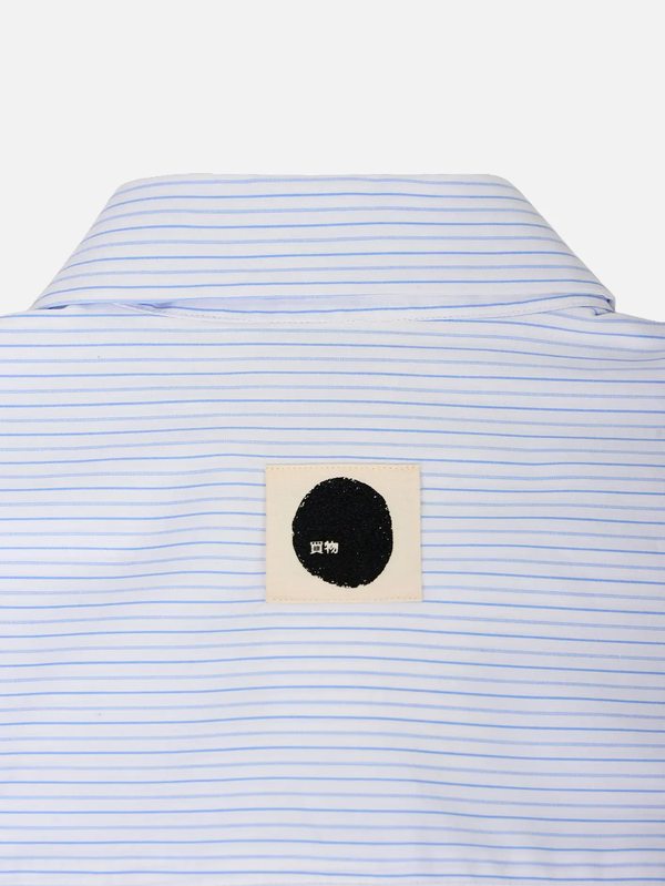 SHOPI GO Sumida Boxy Shirt – Light Blue & White, arka görünüm; ince çizgili kumaş ve krem yama üzerinde siyah daire