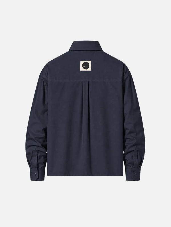 shopi go Meguro Regular Shirt – Dark Navy, arka görünüm; üst sırtında bej kare üzerinde siyah daire logo